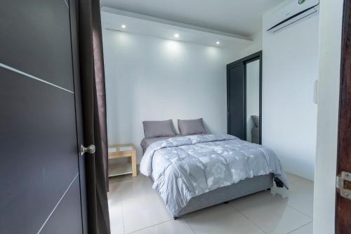 ein Schlafzimmer mit einem Bett in einem weißen Zimmer in der Unterkunft ISLAND RESIDENCE Plaisance - Mauritius - 15718 in Plaine Magnien
