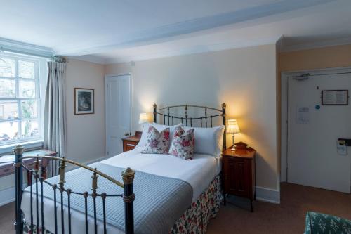 a bedroom with a bed with white sheets and pillows at Spread Eagle Inn in Stourton