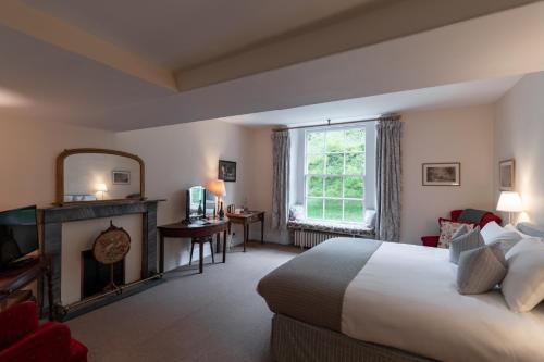 um quarto de hotel com uma cama e uma lareira em Spread Eagle Inn em Stourton