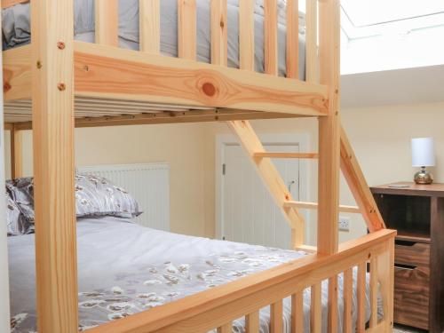 a wooden bunk bed in a bedroom at Sawtons Cottage 1 in Dawlish