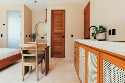 eine Küche mit einem Tisch und ein Schlafzimmer mit einem Bett in der Unterkunft Cucu Hotel El Cuyo in El Cuyo
