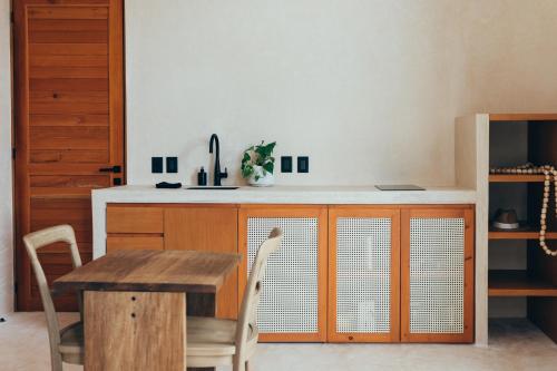 a kitchen with a wooden table and a table and chairs at Cucu Hotel El Cuyo in El Cuyo