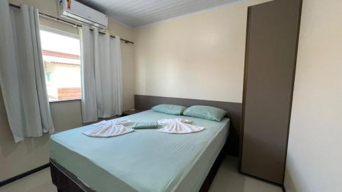 a bedroom with a bed with two towels on it at Lencóis Ville Residence in Barreirinhas