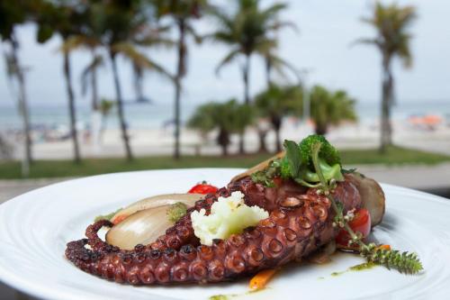 a plate of food on a table near the beach at Doral Guarujá in Guarujá