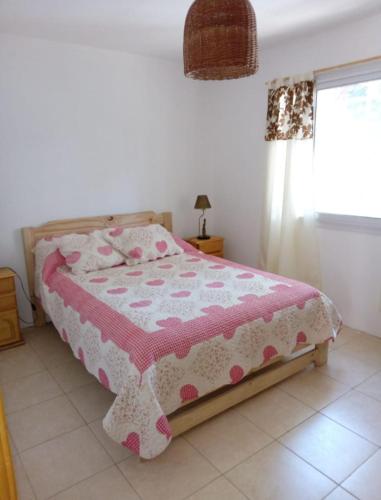 1 dormitorio con 1 cama con manta rosa y blanca en descanso, en Mar Azul