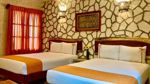 a hotel room with two beds and a window at Hotel Casa San Juan in Valladolid