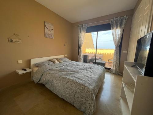 - une chambre avec un lit et une grande fenêtre dans l'établissement Duquesa village, à Manilva