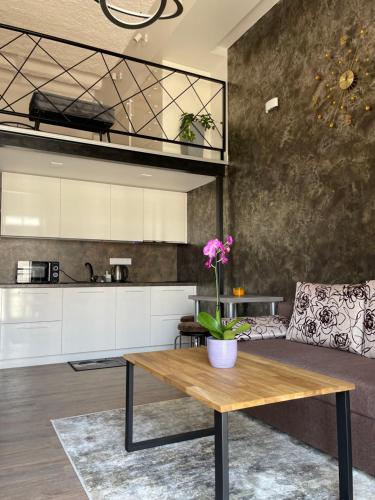 uma cozinha e sala de estar com uma mesa de madeira em Radio city loft em Kaunas