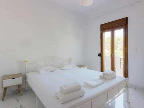 - une chambre blanche avec un grand lit blanc et des serviettes dans l'établissement Hersonissos Modern One Bedroom Apartment Beachside, à Chersónissos