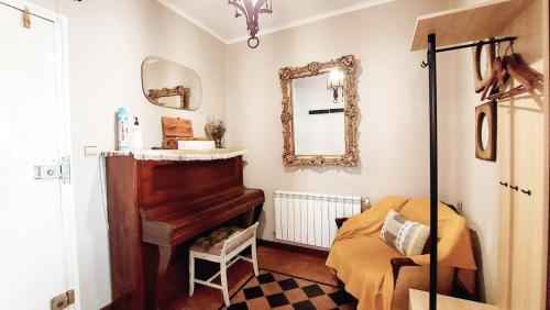 a bedroom with a piano and a mirror at Casita Bonita in Castejón de Sos