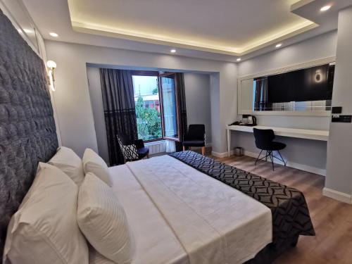 a bedroom with a large white bed and a desk at Luxx Garden Hotel in Istanbul