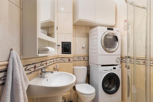 a bathroom with a sink and a washing machine at P&O Serviced Apartments Plac Konstytucji in Warsaw