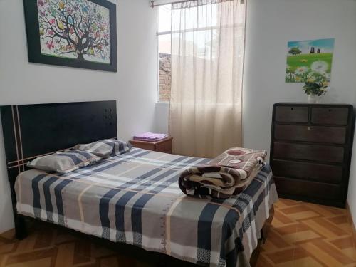 ein Schlafzimmer mit einem Bett mit einer blauen und weißen Decke in der Unterkunft Departamento - Los Mitos del Parque M2 in Chiclayo