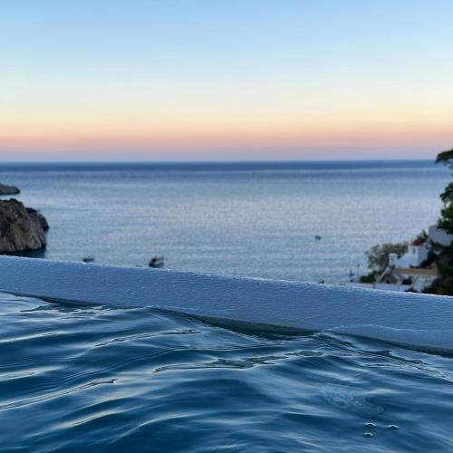 a swimming pool with the ocean in the background at Agnantema luxury suites in Karpathos Town