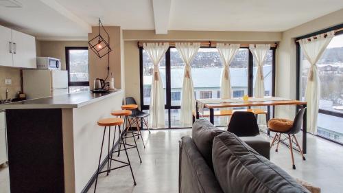 a kitchen and living room with a couch and a table at Amanecer del Fuego II in Ushuaia