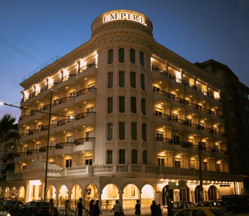 a large white building with a sign on it at Hotel Empire Albania in Durrës