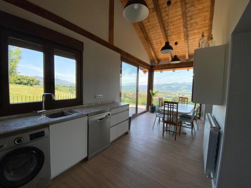 een keuken met een wastafel en een tafel met stoelen bij Casa Los Rinocerontes in Penagos