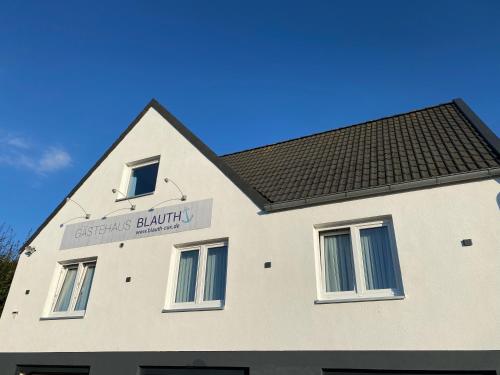 a white building with a sign on the side of it at Gästehaus Blauth in Cuxhaven