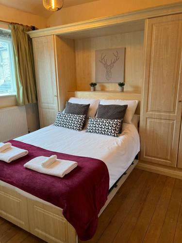 a bedroom with a large bed with two towels on it at Cosy cottage with a canal view in Hebden Bridge