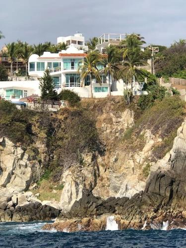una casa grande en la cima de una montaña rocosa en Hermosa Villa con alberca infinita Playa Zipolite, en Puerto Ángel