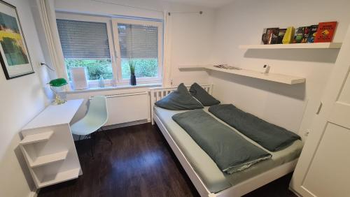 a bedroom with a bed and a desk and a window at kleines Ferienhaus in Herford, freihstehend, eigener Eingang in Herford