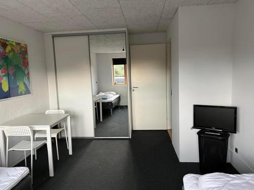 a room with a room with a table and a mirror at Ebbesens Bed and Bath - two double rooms in Herning