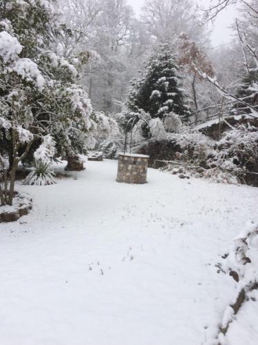 a snow covered park with a bench and trees at Villa Franca in Castelluccio Inferiore