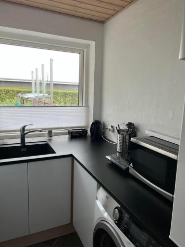 a kitchen with a black counter top and a window at Ebbesens Bed and Bath - two double rooms in Herning