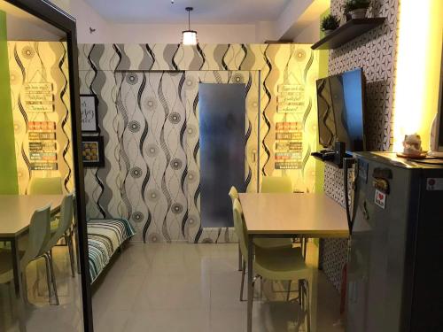 a dining room with a table and chairs and a wall at SMDC Light Residences Condominium in Manila