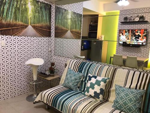 a living room with a couch with pillows at SMDC Light Residences Condominium in Manila