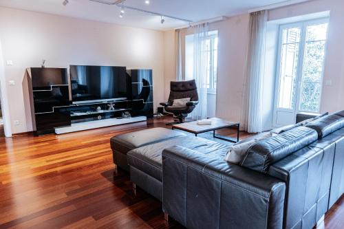 a living room with a couch and a large television at Montreux Grand Rue - Swiss Hotel Apartments in Montreux