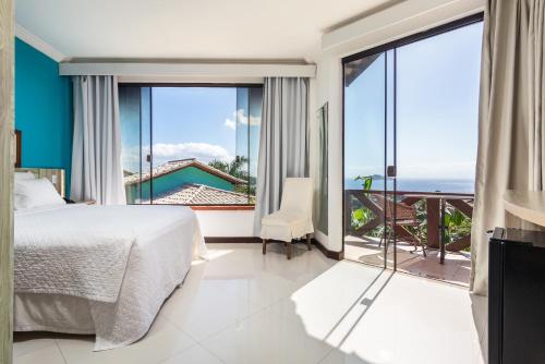 1 dormitorio con cama y vistas al océano en Costa do Sol Boutique Hotel en Búzios
