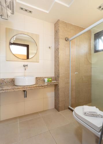 a bathroom with a sink and a shower at Costa do Sol Boutique Hotel in Búzios