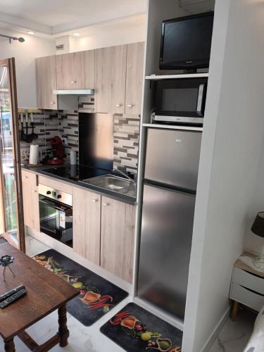 une cuisine avec un réfrigérateur en acier inoxydable et une table dans l'établissement BELLE MAISON A Ménars, à Menars