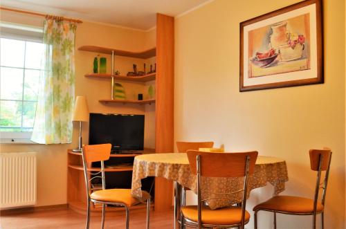 a dining room with a table with chairs and a computer at Apartament Teresa Krynica Morska in Krynica Morska