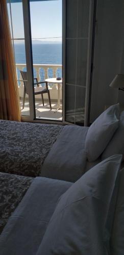 a bedroom with a bed with a view of the ocean at Marisini Sea View in Batsi