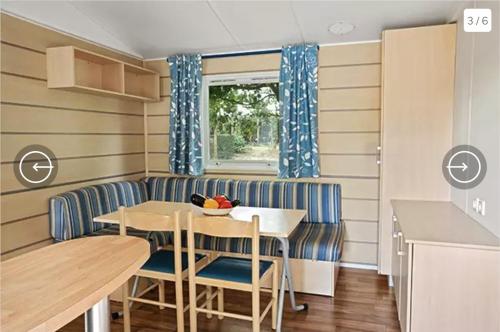 a caravan dining room with a table and chairs at Mobil-Home Camping de la dune Blanche in Camiers
