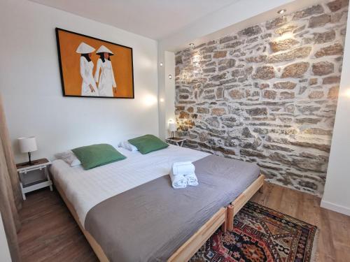Ce lit se trouve dans un dortoir doté d'un mur en pierre. dans l'établissement L'Ecrin des bords de l'Erdre - Les Maisons de Madeleine, à Nantes