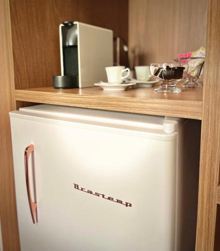 a white refrigerator with a counter on top of it at Casa Três Rios - Campos do Jordão in Campos do Jordão