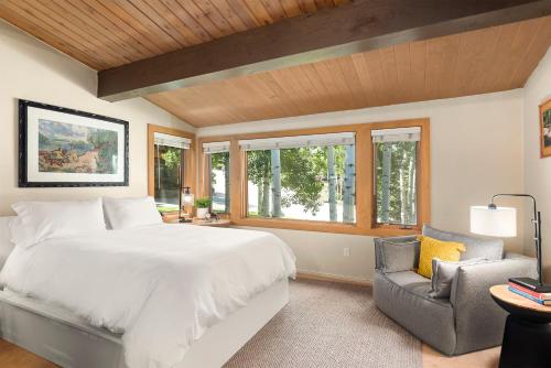 a bedroom with a large bed and a chair at Aspenwood by Snowmass Vacations in Snowmass Village