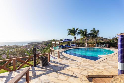 a swimming pool with a view of the ocean at Costa do Sol Boutique Hotel in Búzios