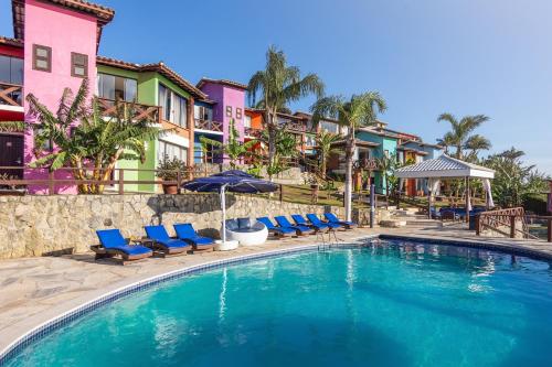 uma piscina com cadeiras e guarda-sóis num resort em Costa do Sol Boutique Hotel em Búzios
