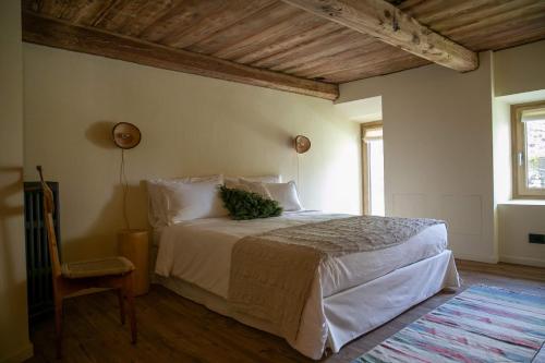 een slaapkamer met een groot bed en een stoel bij bnb Uja in Balme