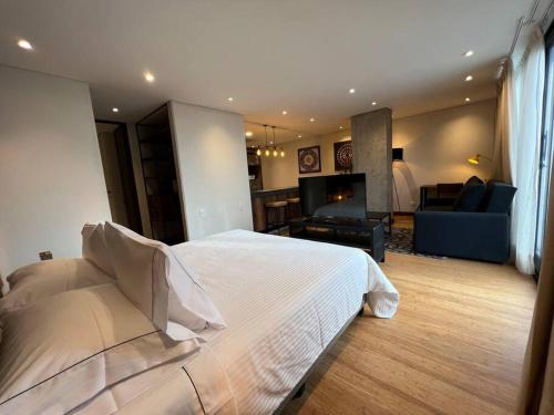 ein Schlafzimmer mit einem großen Bett und ein Wohnzimmer in der Unterkunft R3 - Lujoso Loft en la Candelaria in Bogotá