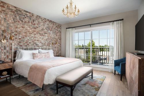 a bedroom with a large bed and a brick wall at The Piccolo in Paso Robles