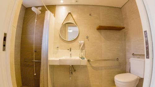 uma casa de banho com um lavatório, um WC e um espelho. em Porto Paúba em Paúba