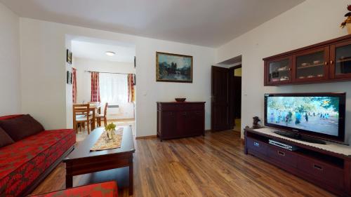 a living room with a couch and a flat screen tv at Apartmán Olívia 8 Hrabovská dolina in Ružomberok
