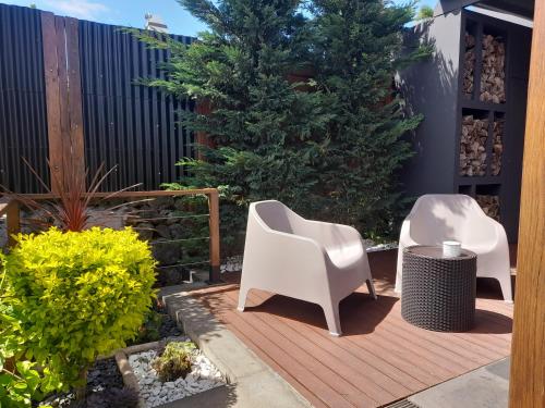 patio z 2 białymi krzesłami na drewnianym tarasie w obiekcie 2Azores With Comfort and Style w mieście Ponta Delgada