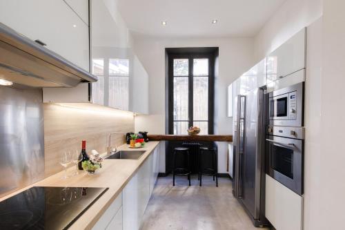 a kitchen with white counters and stainless steel appliances at Villa Maiffret YourHostHelper in Cannes