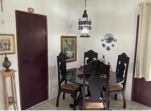 een eetkamer met een glazen tafel en stoelen bij Chalé romântico , rústico e vista de tirar o fôlego in Guaramiranga